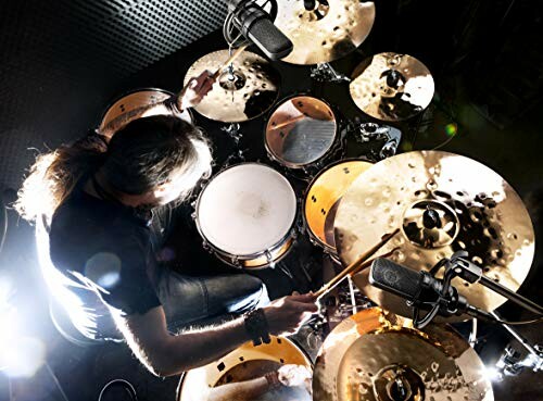 Overhead view of a drummer playing a drum set with microphones