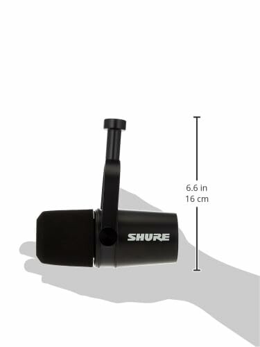 Shure microphone held in hand, showing its size.