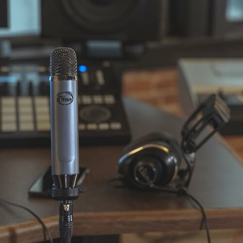 Close-up of a studio microphone and headphones on a desk